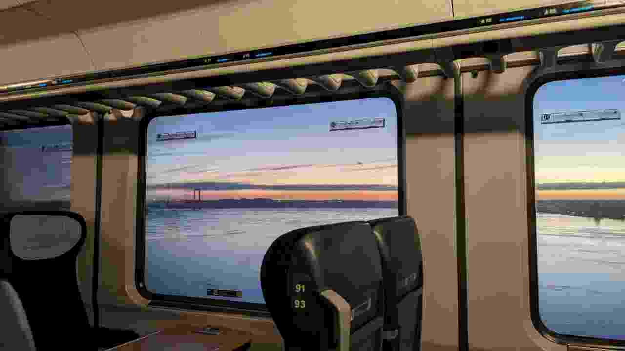 The Lillebælt seen form inside a train; a bridge in the background, IC seats and window panes of the train visible; Strong jpg compression artifacts.